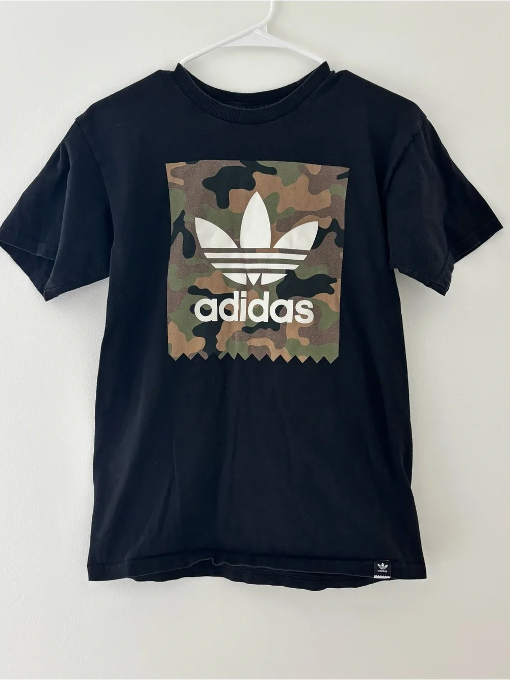 Adidas black t-shirt with white Adidas logo on camouflage background