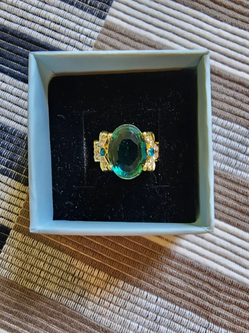 Aqua colored stone in gold colored band. Size 5.