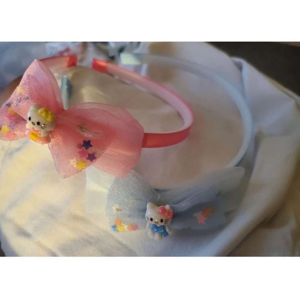 Four Hello Kitty headbands with small figurine
