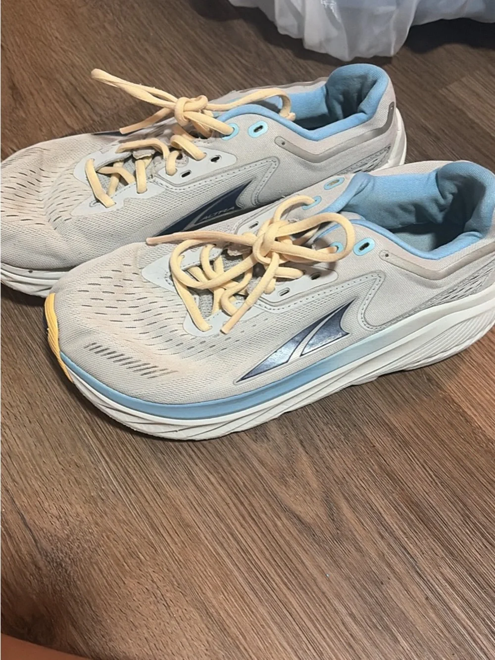 Altra light blue & cream cushioned running shoes with pale yellow laces